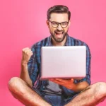 Guy laughing in front of Laptop Graphic