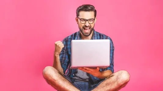Guy laughing in front of Laptop Graphic