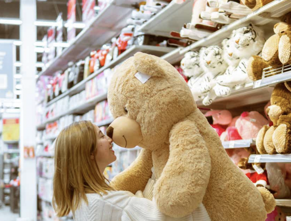 Girl hugging a teddy bear in a store