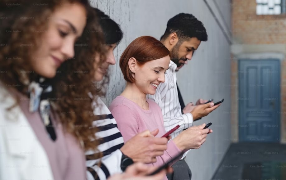 A group of young people on their mobile phones.