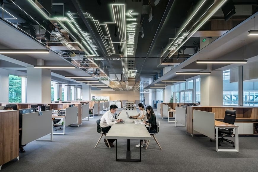 A huge company workspace with a few employees working.