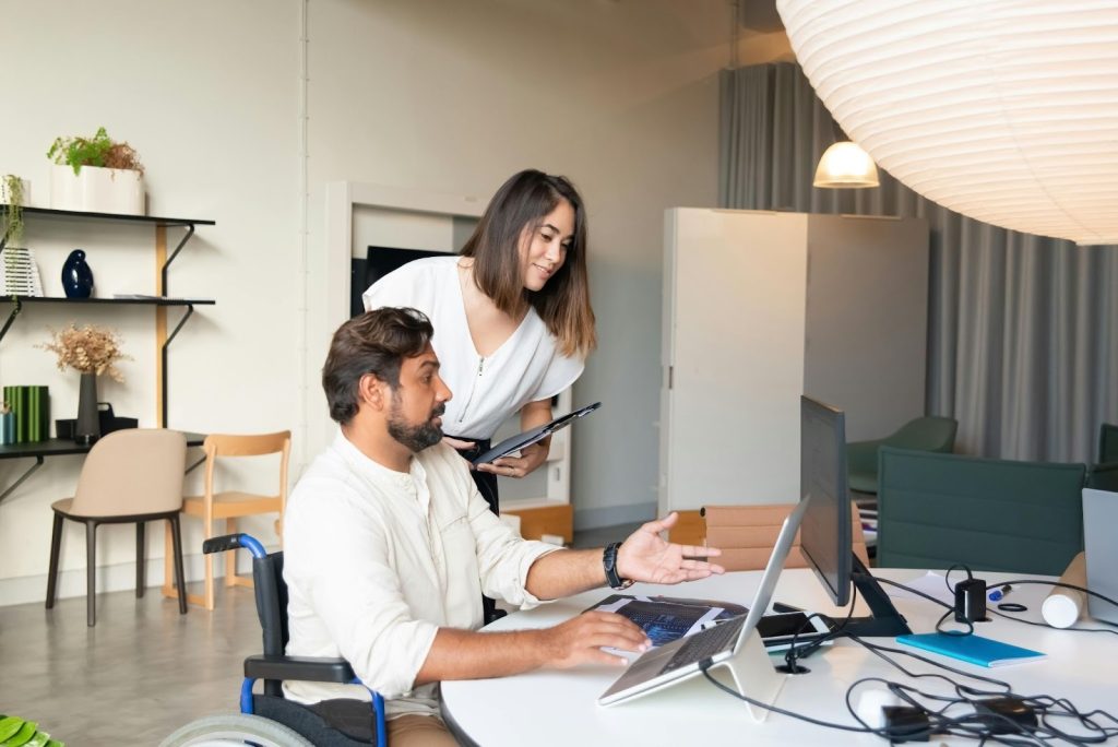 Two professionals reviewing something on a desktop computer.