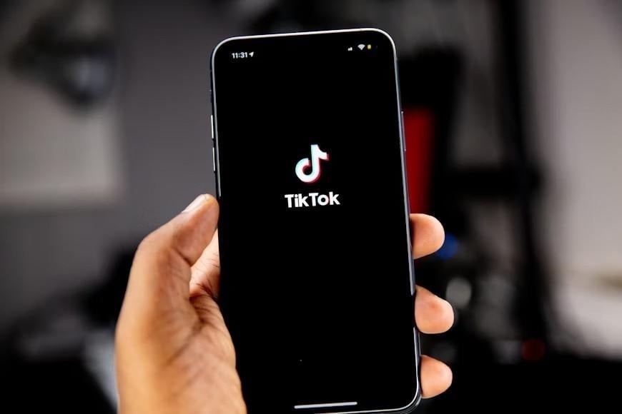 A person holding an iPhone running TikTok.