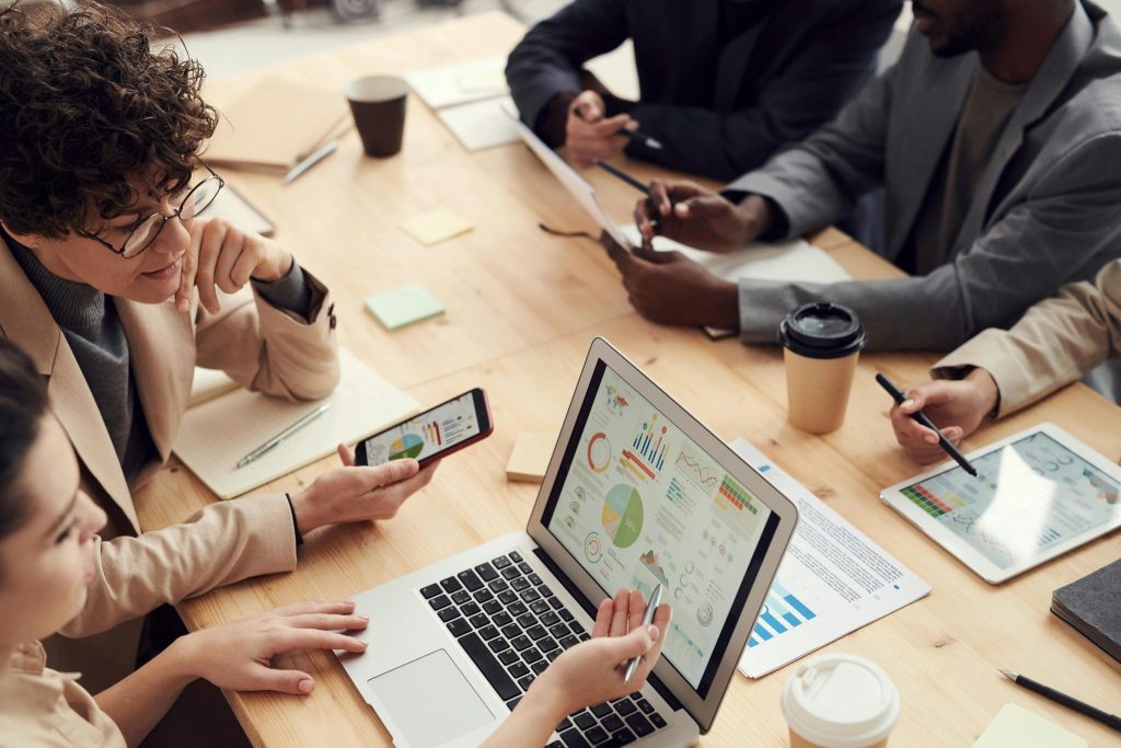 A group of digital marketers working on a laptop showing online store analytics.