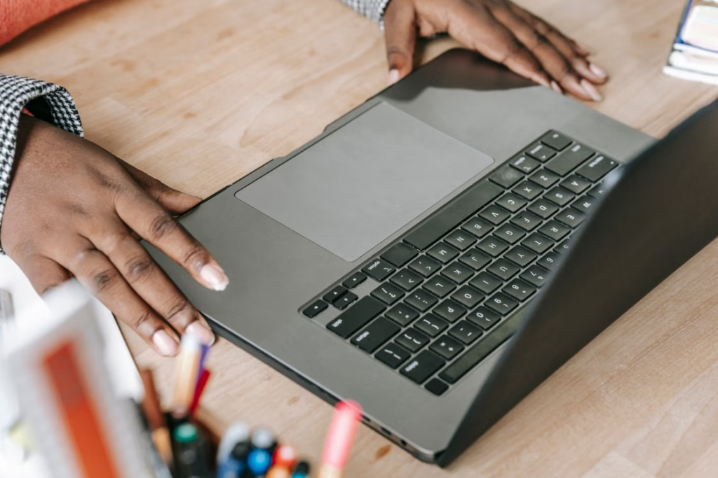 Close-up of woman's hands on laptop keyboard in a professional office environment.