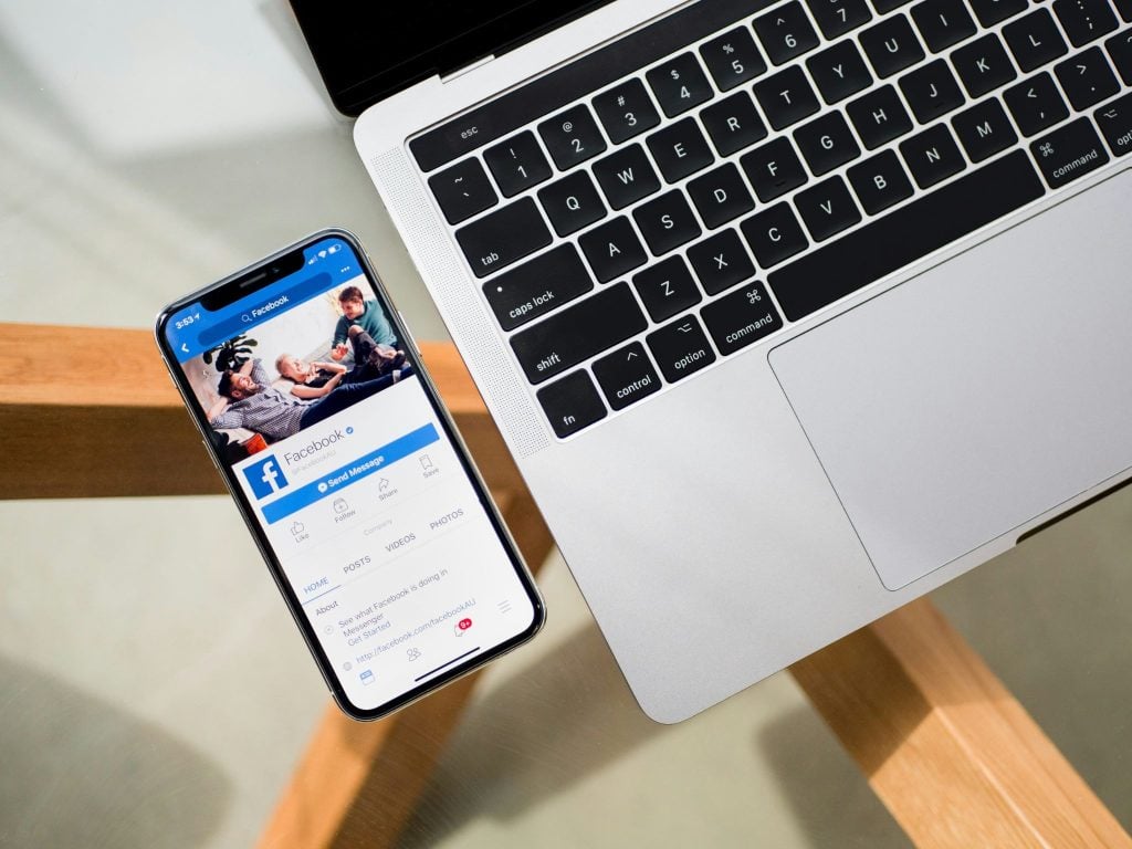Facebook app and page open on a person’s mobile phone