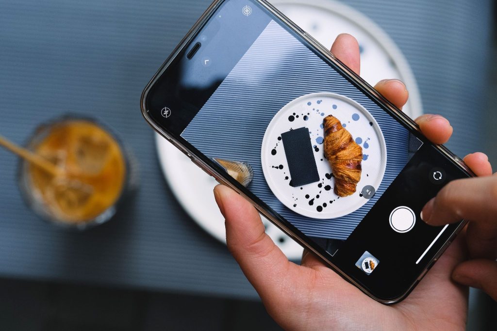 Person taking a photo of food to post on his Instagram story